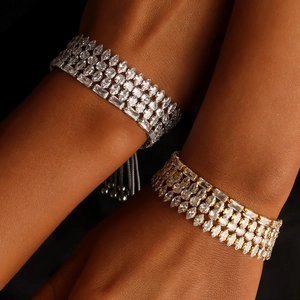 Detailed close-up of gold and silver plated V-shape bracelets with cubic zirconia