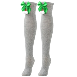 Detailed view of grey over-knee Christmas socks with green bows and white pom-poms