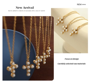 Detail of gold cross pendant necklace featuring inlaid white pearls and elegant link chain