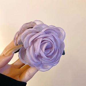 Detailansicht einer lila Organza-Blumenhaarklammer mit zarten, geschichteten Blüten