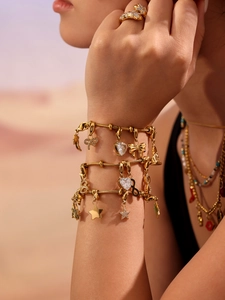 Détail du bracelet chaîne serpent doré avec grands charms cœur en zircon et étoiles