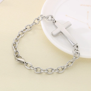 Polished silver stainless steel cross bracelet on a minimalist display platter