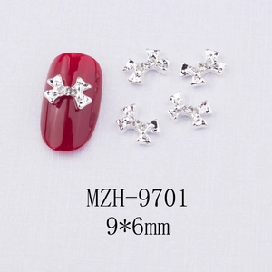 Bijou d'ongle nœud argenté avec strass montrant la taille 9x6mm sur un faux ongle