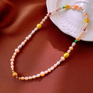 Baroque necklace with pink pearls and gold magnetic clasp on vintage satin fabric