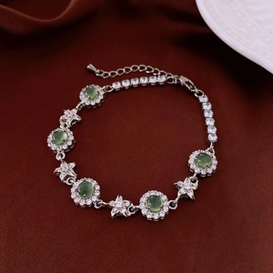 Détail du bracelet argenté avec pierres rondes vertes et oxydes de zirconium en étoile