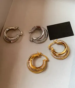 Close-up of double-layered geometric hoop earrings with sparkling zircon inlay