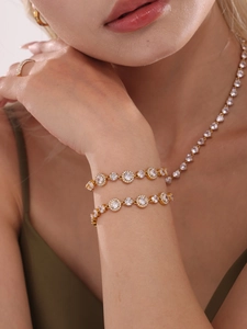 Close-up of gold tone bracelet featuring circular links with 5A cubic zirconia stones