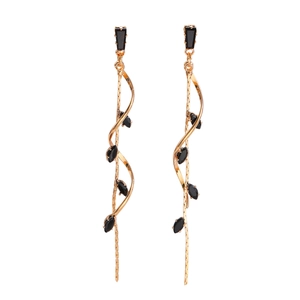 Detail of long gold tassel earrings with black marquise zircon and elegant spiral design
