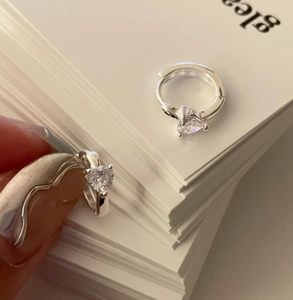 Close-up of minimalist S925 sterling silver hoop earrings with heart-shaped zirconia stones