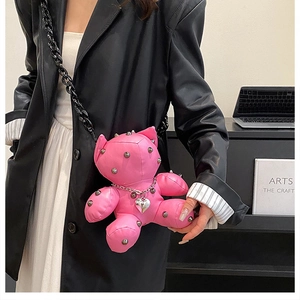 Close-up of pink PU leather bear bag with metal studs and silver heart pendant