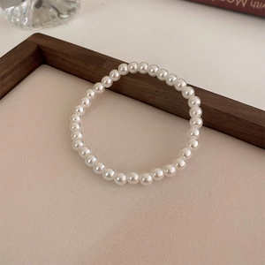 Gros plan d'un bracelet en perles d'eau douce brillantes sur un support en bois