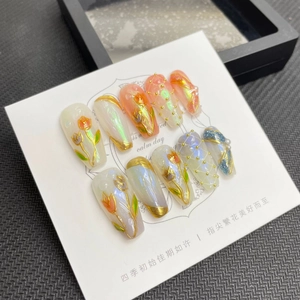 Detail view of handmade press-on nails with 3D tulip hand-painting and pearl accents