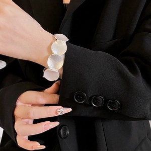 Chic silver circular拼接 bracelet shown on model against a dark background outfit