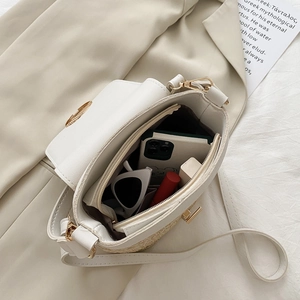 Detail of straw patchwork crossbody bag showing spacious interior with daily essentials