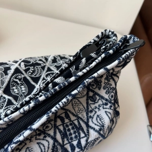 Detailed macro view of the embroidery and dual metal zippers on the canvas bag