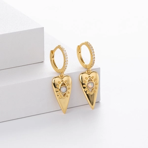 Detail view of heart-shaped evil eye earrings with gold finish and opal inlay