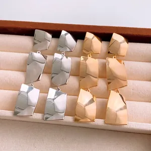 Minimalist geometric square tassel earrings in gold and silver plating on jewelry tray