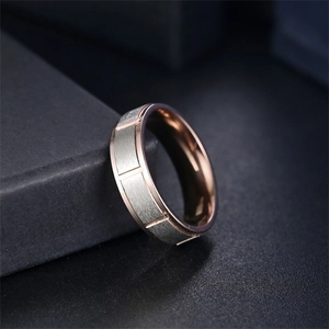 Vue rapprochée d'une bague en acier titane avec extérieur brossé et intérieur or rose