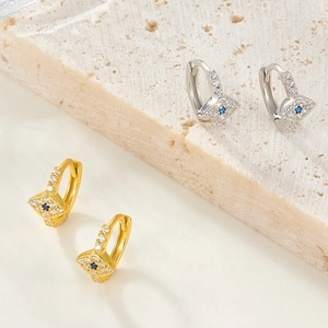 Detail of 925 silver evil eye hoop earrings with blue stones in gold and silver finish