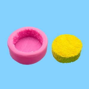 Pink silicone waffle mold with yellow textured insert for DIY candle or cake making
