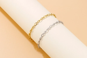 Detailed shot of minimalist gold and silver link bracelets on a display stand