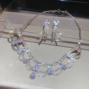 Dettaglio del set di gioielli in argento con strass scintillanti e ciondoli a goccia