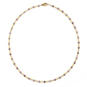 Macro shot of purple faceted stone beads and gold tube links on a stylish sweater necklace