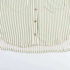 Détail de tissu rayé vert et blanc avec des boutons en bois et un ourlet arrondi