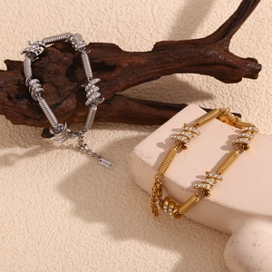 Detail view of gold and silver knot bracelets with micro-inlaid crystals and 18K hallmarks