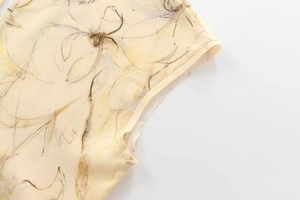 Gros plan des coutures sur la robe dos nu jaune clair avec imprimé floral vert