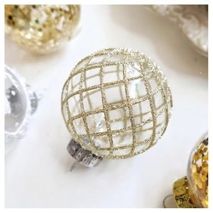 Close-up of a clear Christmas ornament with gold glitter grid pattern and silver cap