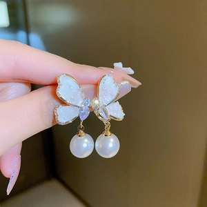 Detailed view of elegant butterfly earrings with white wings and hanging pearl charm