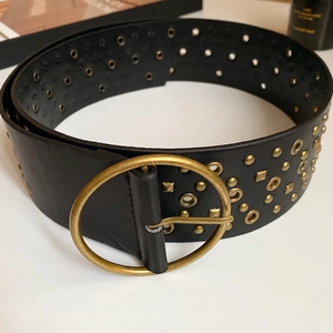 Detail of black leather waist chain with golden rivets and large round metal buckle