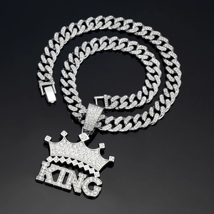 Macro shot of silver hip-hop cuban chain with rhinestone-studded king crown pendant