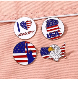 Close-up of four American flag and Liberty enamel pins pinned on pink denim fabric