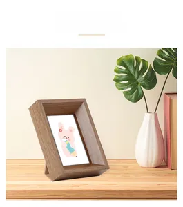 Detail of a dark walnut wood photo frame with thick borders on a desktop setting