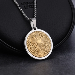 Macro shot of two-tone Celtic cross pendant with honeycomb texture on a steel chain