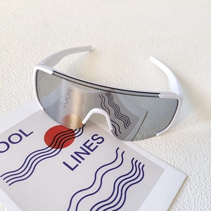 Macro detail of white wrap-around sports goggles with silver lenses on a minimalist card