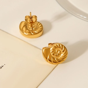 Macro detail of 18K gold-plated stainless steel conch shell stud earrings with spiral texture