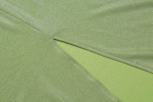 Macro detail of green knitted fabric with shimmering silver lurex yarn textures