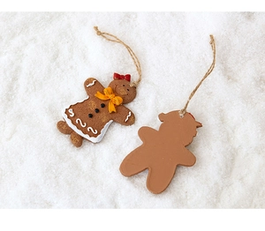 Detail view of gingerbread man ornaments with realistic texture on a snowy background