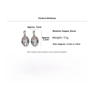 Detailed view of silver needle snake earrings with emerald accents and zircon pavé