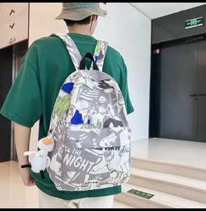 Detail view of graffiti print backpack with white duck pendant and street art design