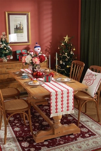 Detailed texture of red and white woven cotton table runner with festive Christmas tassels