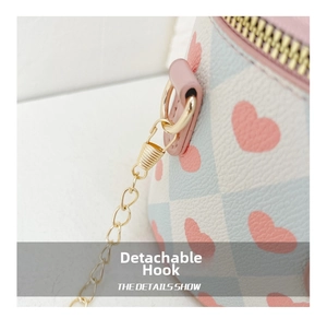 Detail of the golden detachable hook and pink heart plaid pattern on a child's bucket bag