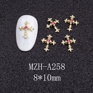 Macro detail of a 8x10mm gold cross nail charm with pink rhinestone for DIY art