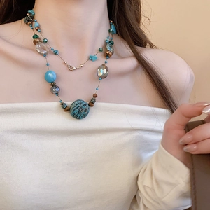 Detail of layered bohemian necklace featuring turquoise beads and champagne crystals