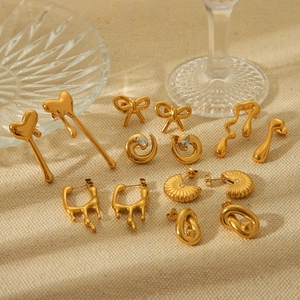 Irregular 18K gold plated stainless steel bow and heart earrings on beige fabric