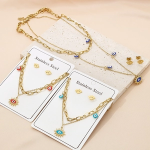 Parure collier et boucles d'oreilles en acier doré avec pendentifs œil bleu et rouge