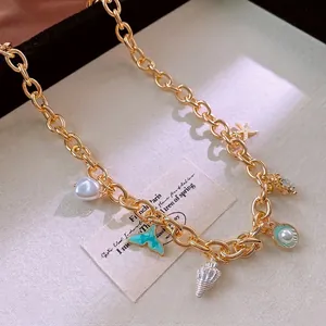Golden chunky chain necklace with shell, fish tail and pearl charms in ocean theme